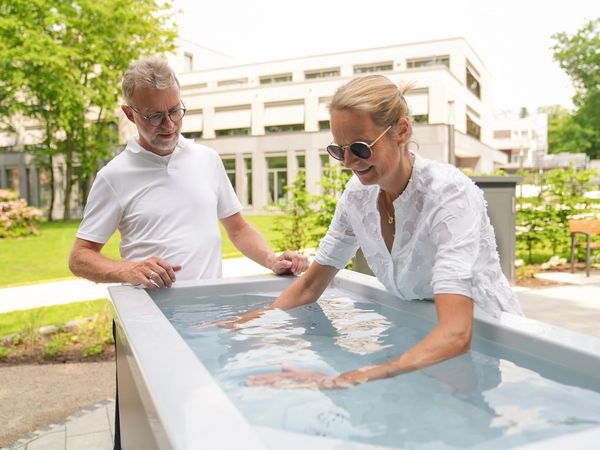 Ein Mann und eine Frau am Kneipp-Armbadbecken in Bad Zwischenahn