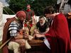 Historisches Flair und lebendige Geschichte im Osnabrücker Land: Eine Gruppe von Personen in mittelalterlichen und römischen Gewändern versammelt sich um einen Tisch, vertieft in ein Gespräch oder Spiel. Im Hintergrund sind Zelte zu sehen, die das Setting eines historischen Reenactments vervollständigen. Dieses Bild vermittelt die Vielfalt und Faszination der kulturellen Veranstaltungen in der Region.