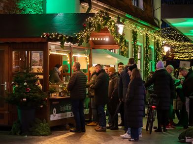 Menschen stehen in der Schlange an einer Bude mit Grünkohl