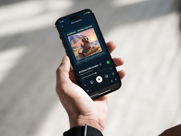 Mobiltelefon mit dem Cover des Podcasts